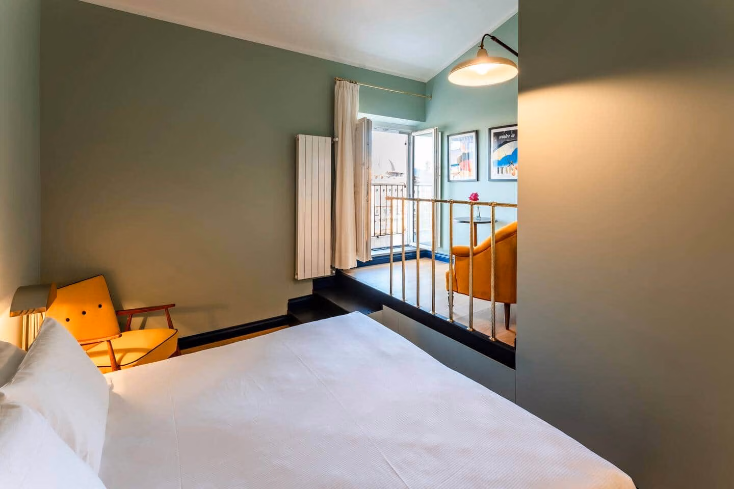 Luxury View Arno — bedroom with white linen and a mustard mid-century armchair