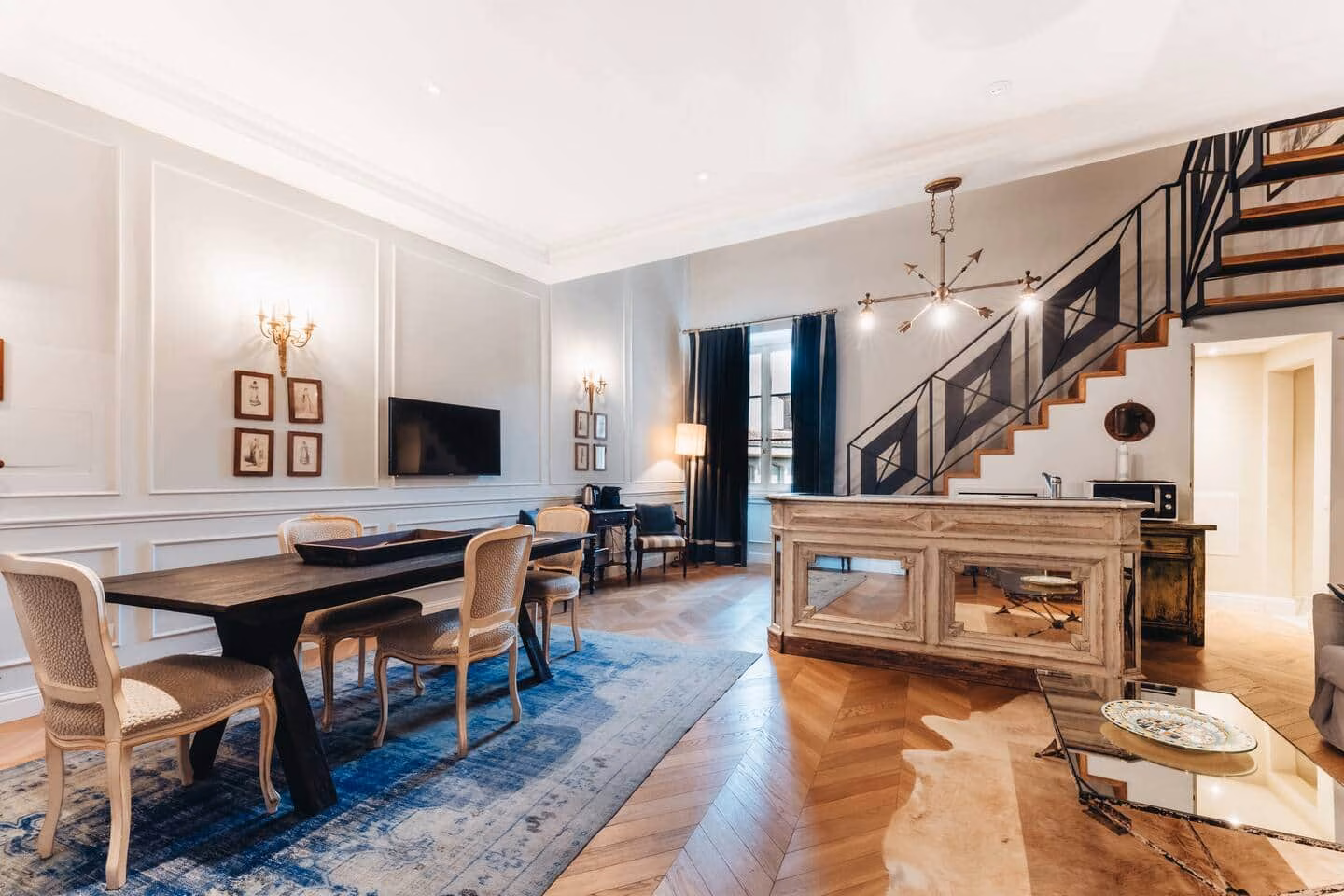Panelled salon with framed portraits, brass sconces and herringbone parquet — La Croce D'Oro Florence