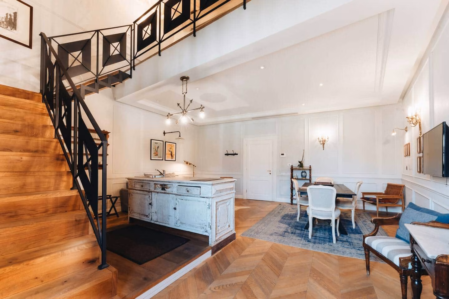 Comfort Suite, Santa Croce — double-height living space with a wooden staircase rising to the loft