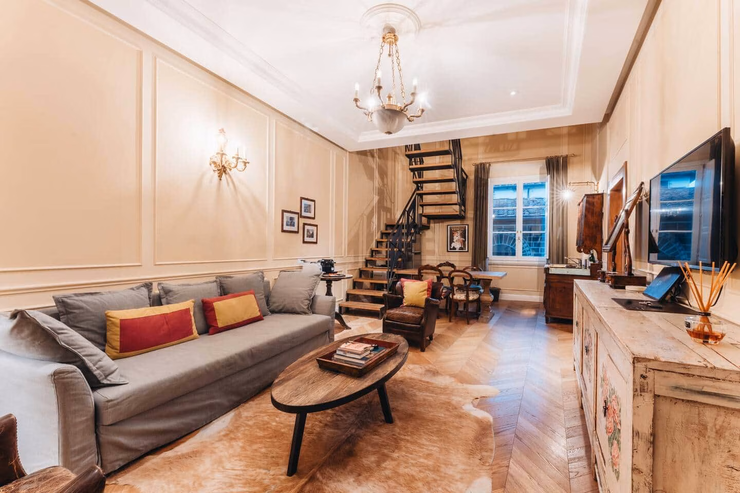 Le Ruote — panelled living room with chandelier and open black staircase