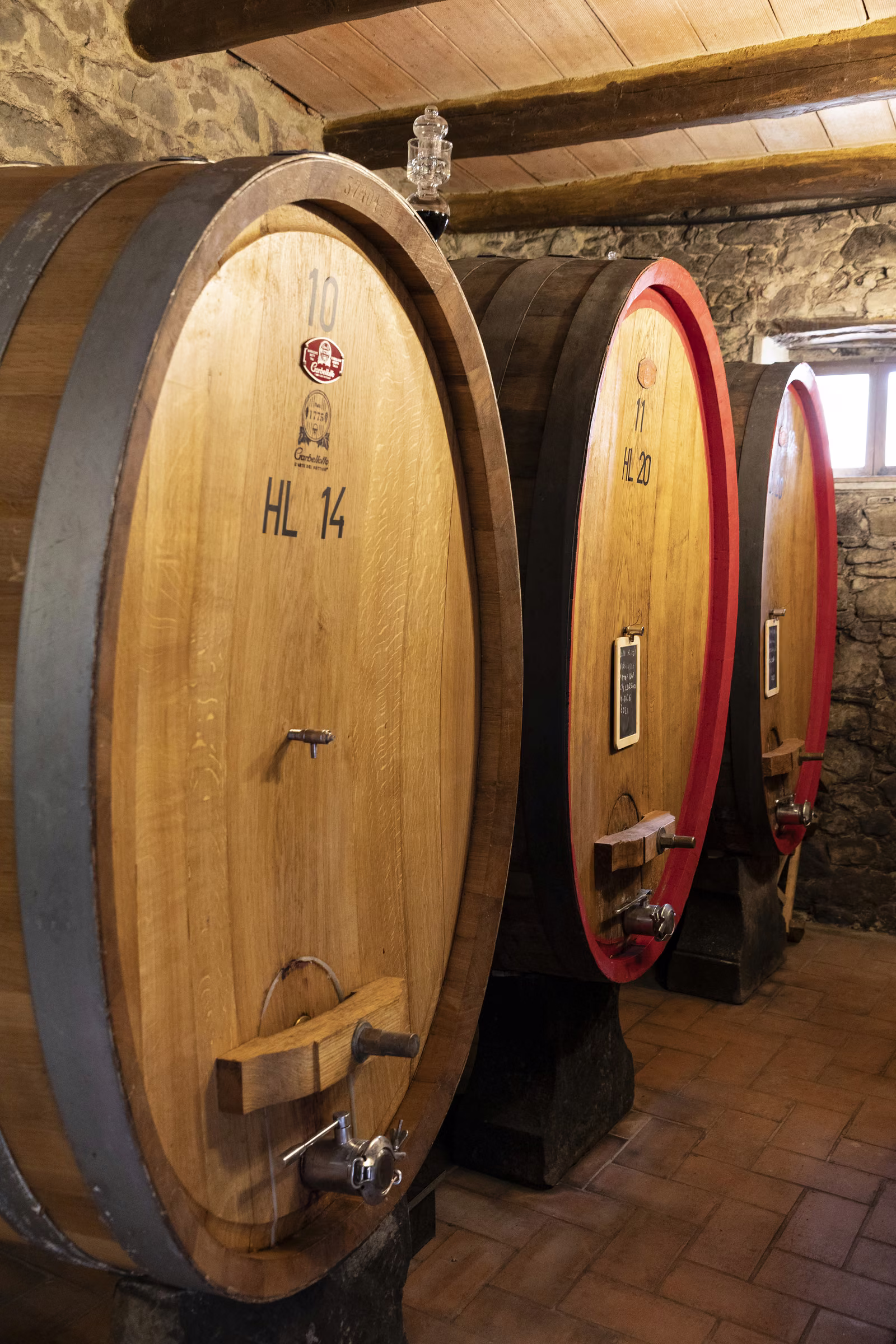 Villa Bordoni wine cellar — aged oak barrels in stone vault, Chianti Classico